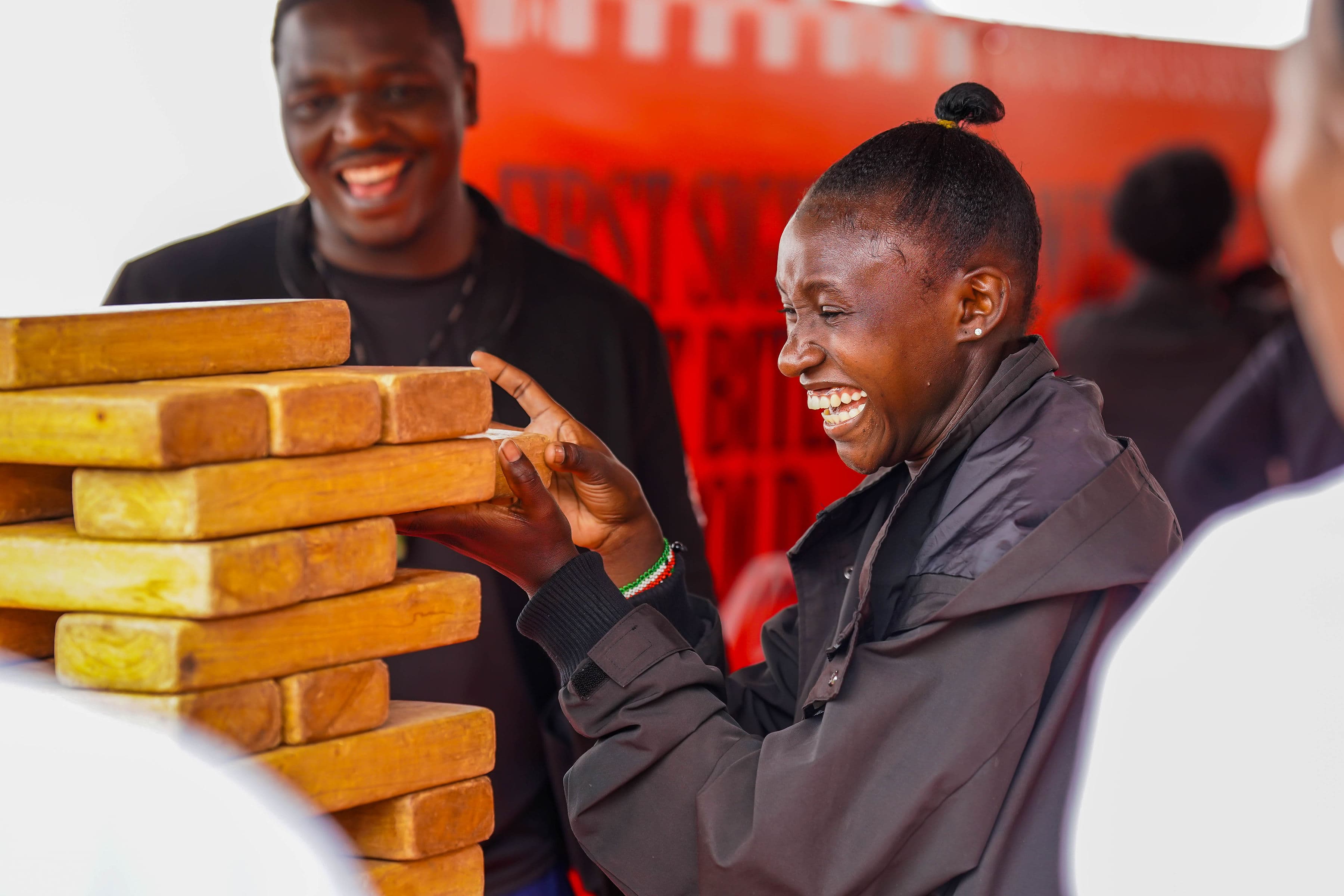 A woman laughing while stacking wooden blocks with a friend