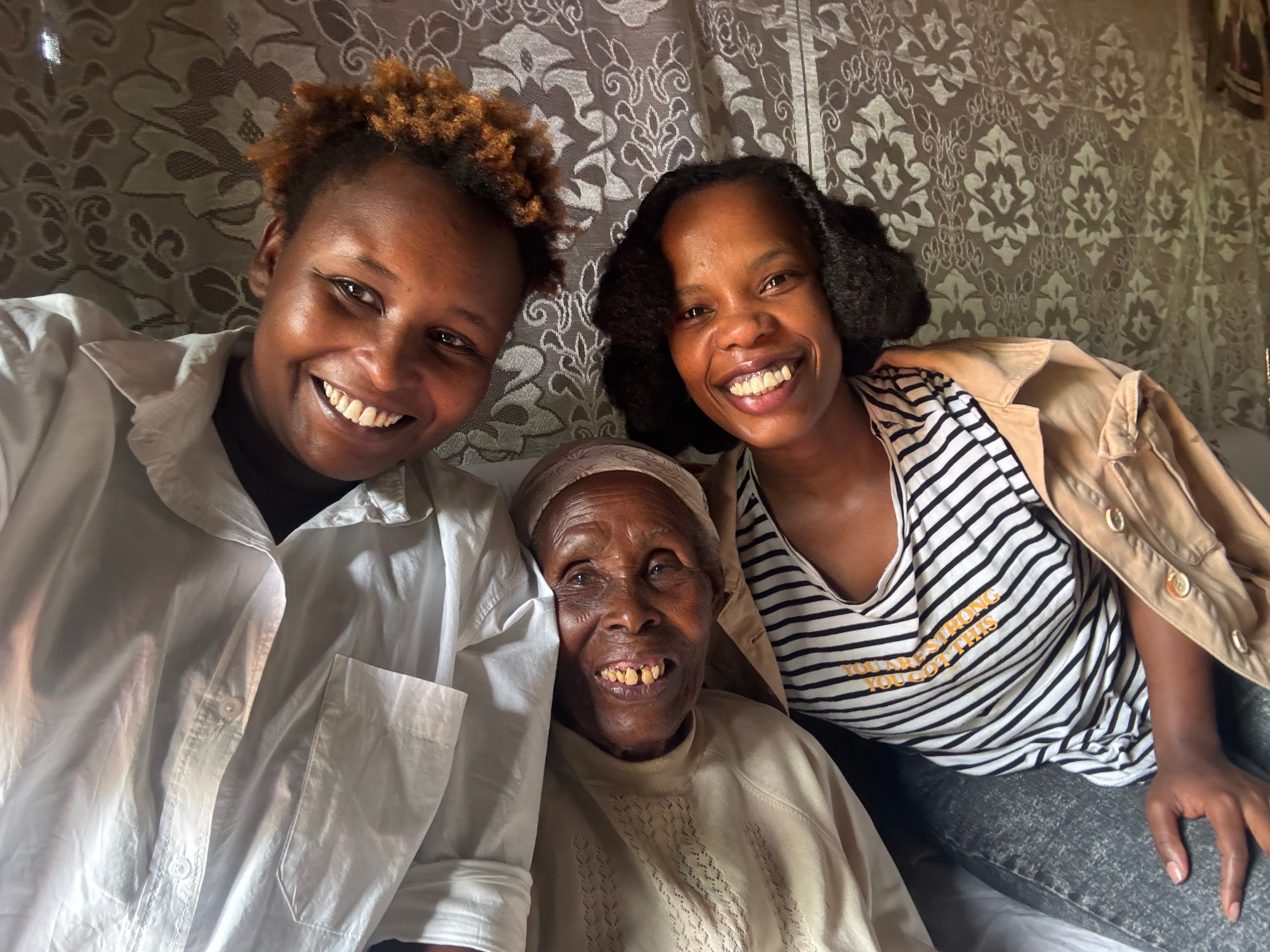 Three generations smiling together, with a grandmother at the centre