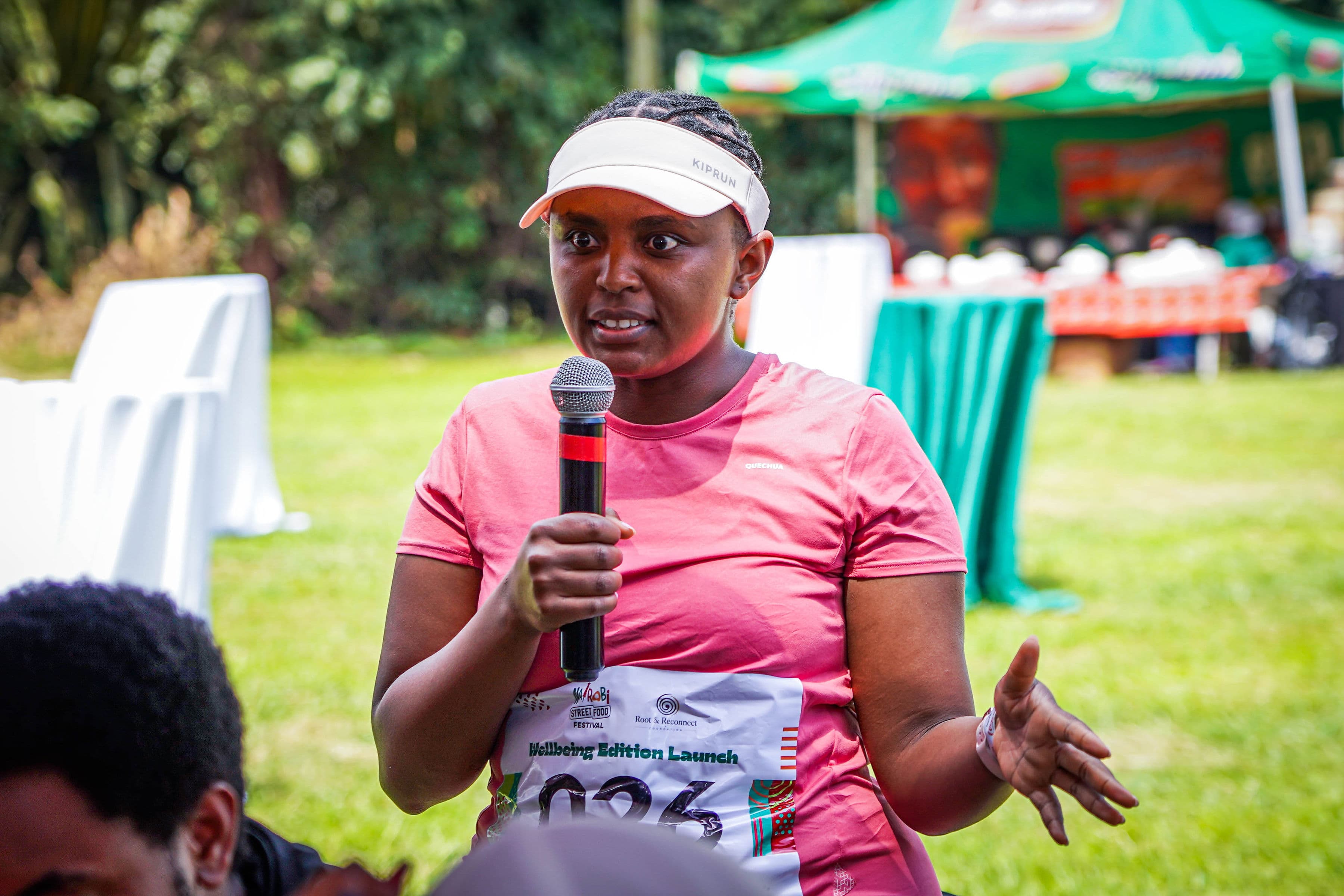 A woman speaking into a microphone during a community wellbeing session
