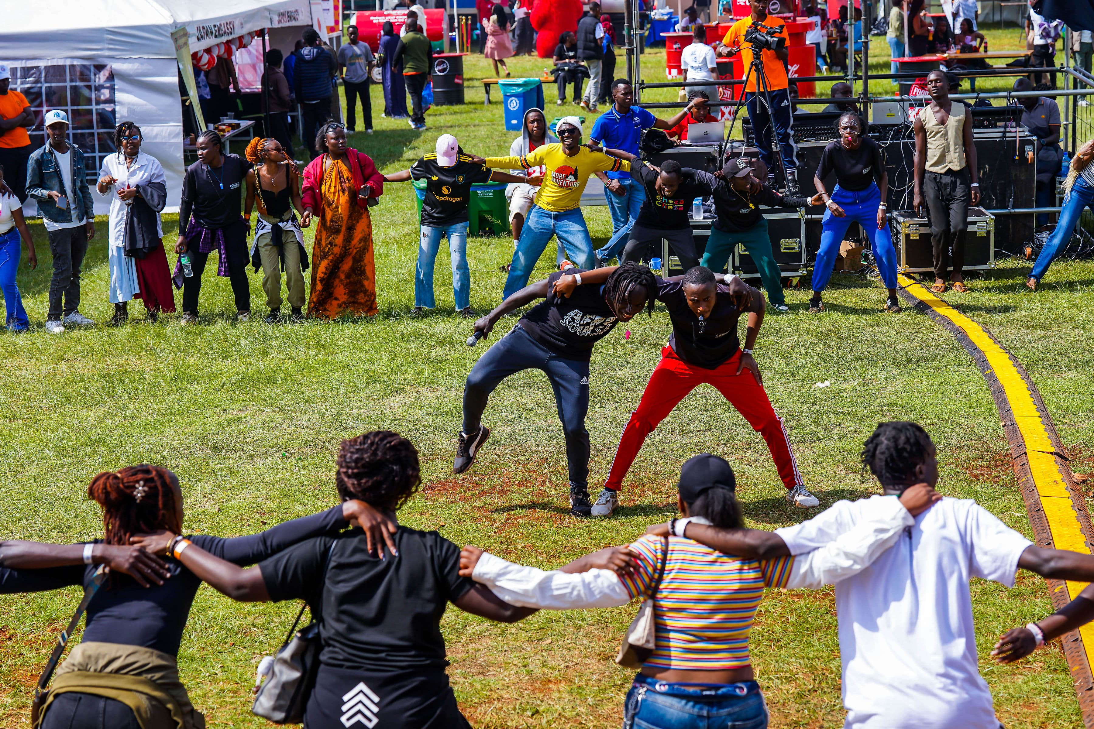 A large circle of people with arms linked together